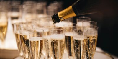 Gläser, gefüllt mit Champagner, Flasche